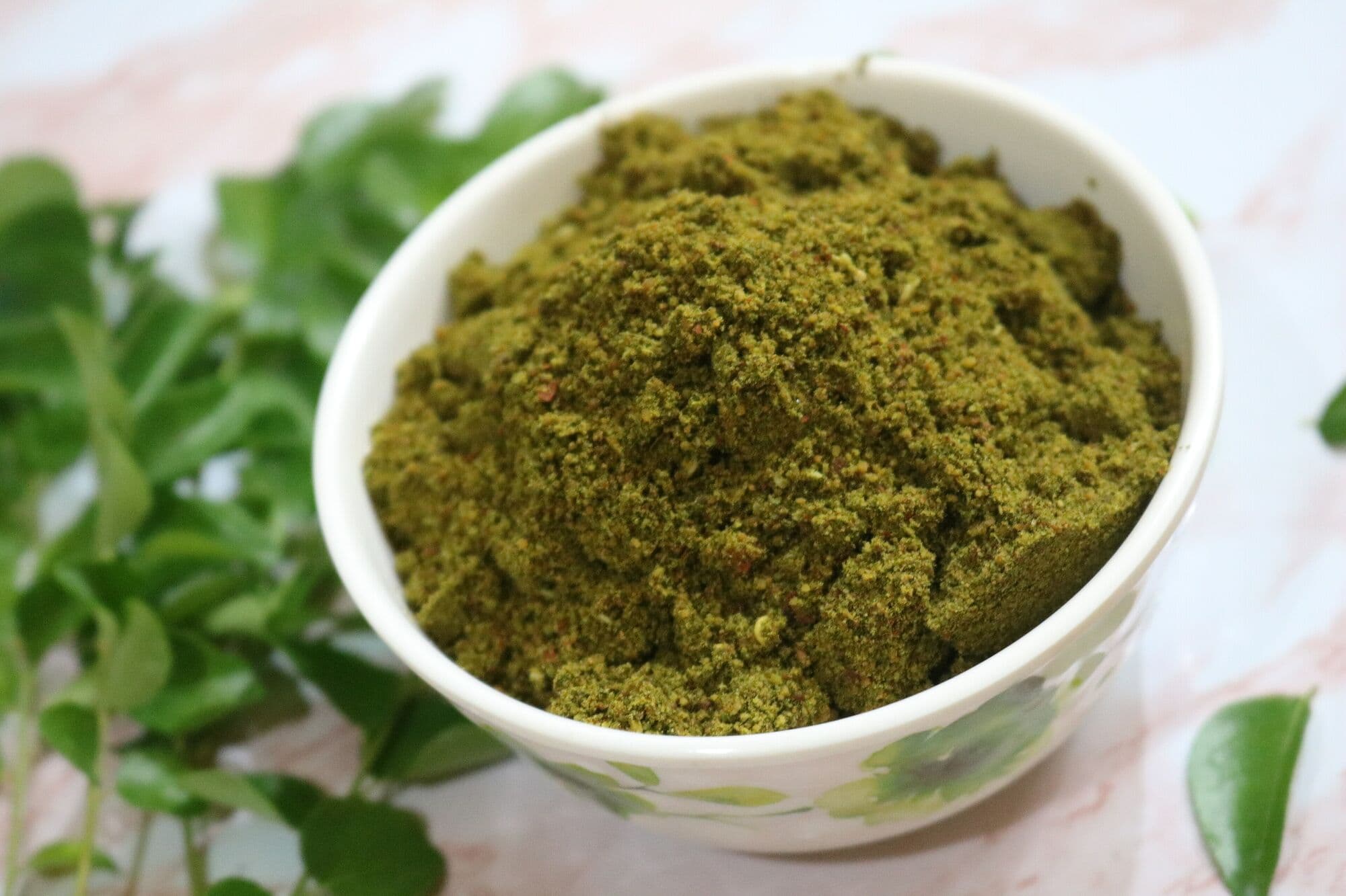A bowl of fine green moringa leaf powder