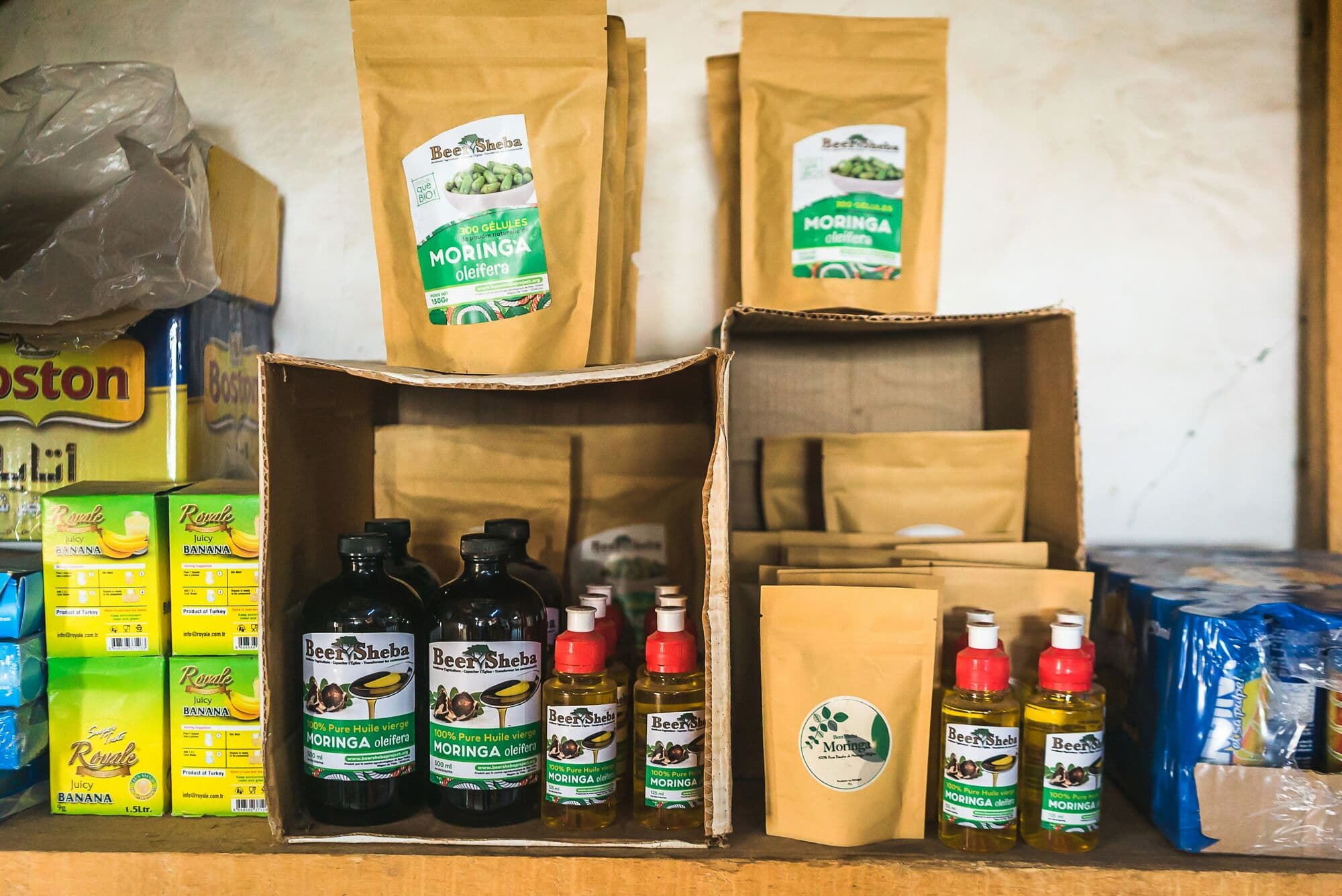 Moringa powder, tea and oil for sale on a shop shelf